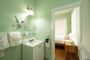 uma casa de banho com um lavatório e um espelho em The Speakeasy Inn and Rum Bar em Key West