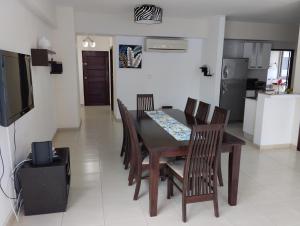 a dining room with a table and chairs and a television at Yc l Estudio av Balboa - GB701A in Panama City