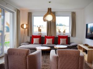 sala de estar con sofá y almohadas rojas en Bergblick, en Werfenweng