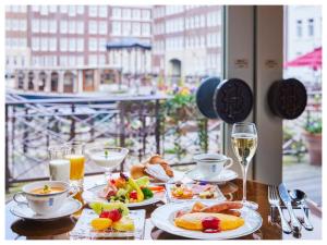 una tavola con piatti di cibo e bicchieri di vino di Hotel Europe Huis Ten Bosch a Sasebo