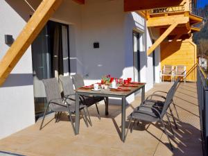 een eettafel en stoelen op een balkon met een tafel en een stoeltje bij Bergblick in Werfenweng