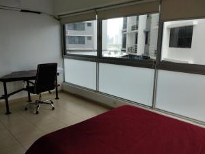 a room with a desk and a chair and windows at Yc l Estudio av Balboa - GB701A in Panama City
