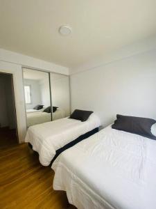 2 camas en una habitación con espejo en Departamento para vacaciones en Salta. en Salta