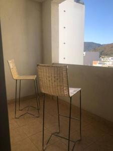 2 sillas sentadas en una habitación con ventana en Departamento para vacaciones en Salta. en Salta