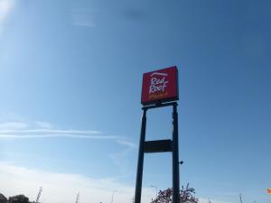 un panneau pour un restaurant rôti sur un pôle dans l'établissement Red Roof Inn Bourbonnais, à Bourbonnais