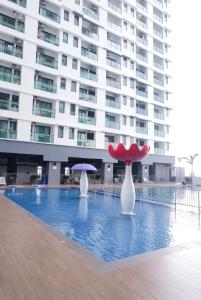a large building with a pool with two vases and an umbrella at EZI homestay Vista Bangi in Kajang