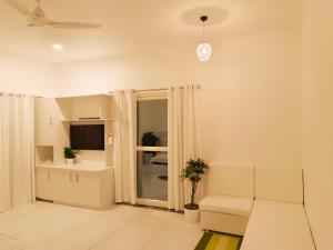 a living room with a couch and a tv at Amritham Holidays Homestay Trivandrum in Trivandrum