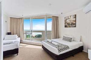 a bedroom with two beds and a large window at Focus Apartments With Ocean Views in Gold Coast