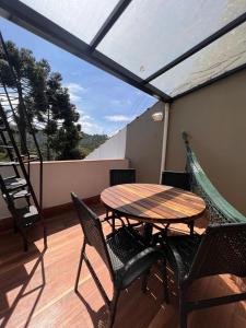 Una mesa y sillas en un balcón con una hamaca. en Cabana Toscana, en Campos do Jordão 14 fotos más