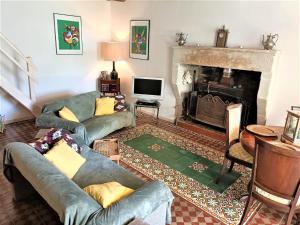 uma sala de estar com dois sofás e uma lareira em Spacious cottage with terrace em Frontenay-sur-Dive