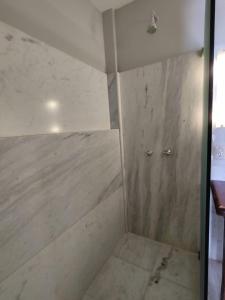 a room with a shower with a concrete wall at Hotel Villa Salvador in Salvador