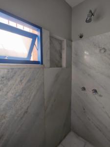uma casa de banho com um chuveiro e uma janela. em Hotel Villa Salvador em Salvador