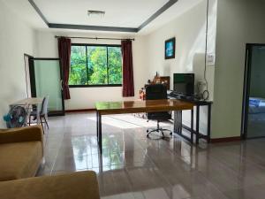 a living room with a desk with a computer on it at ST Mansion in Khanom