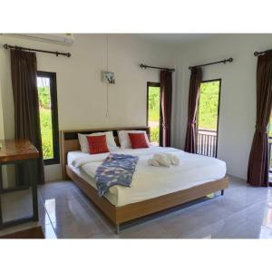a bedroom with two beds in a room with windows at ST Mansion in Khanom +50 photos