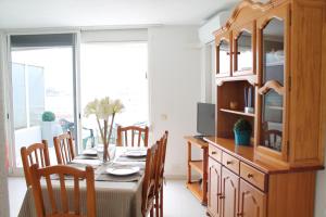 une salle à manger avec une table, des chaises et une télévision dans l'établissement Apartamento Picasso, à Peñíscola