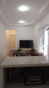 uma sala de estar com um sofá e uma mesa em Apto novo com piscina e pátio na praia dos Ingleses em Florianópolis