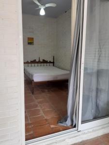 - une vue sur une chambre avec un lit à travers une fenêtre dans l'établissement Suíte a duas quadras da Praia e perto da Ilha do Mel, à Pontal do Paraná