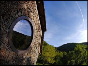 ein rundes Fenster an der Seite eines Steingebäudes in der Unterkunft Malrieu in Le Fel