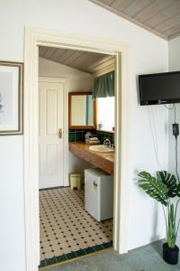 uma casa de banho com uma porta aberta para uma casa de banho com um lavatório em Jardine Lodge - Can sleep 22! em Corryong