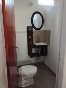 a bathroom with a white toilet and a mirror at Pachamama cabañas en la montaña in Mina Clavero