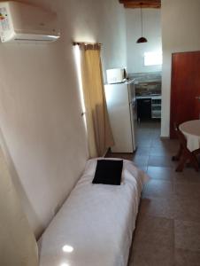 Habitación con cama en la esquina de una cocina en Pachamama cabañas en la montaña en Mina Clavero