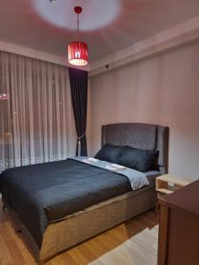 sypialnia z dużym łóżkiem i dużym oknem w obiekcie Luxury apartment in Istanbul w Stambule
