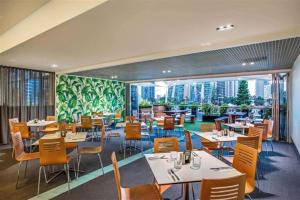 um restaurante com mesas e cadeiras e uma grande janela em Deluxe Twin Studio in Surfers Paradise em Gold Coast