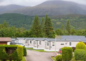 a row of houses with a mountain in the background at Ben Nevis Holiday Park in Banavie