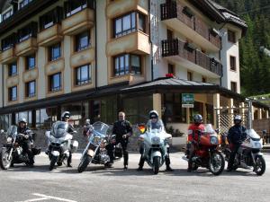un grupo de motocicletas estacionadas frente a un edificio en Biker Hotel Al Gallo Forcello, en Passo Pramollo