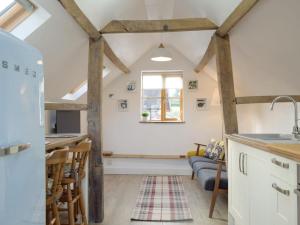 cocina y sala de estar con vigas de madera. en The Granary en Clee Saint Margaret