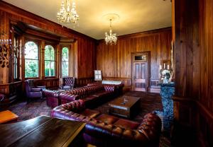 a living room with leather furniture and wooden walls at Woodlands of Marburg in Marburg