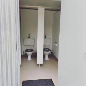 un baño con 3 aseos en una habitación en Trethowels Grey Hidden hut en St Austell