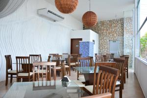 a dining room with wooden tables and chairs at Happy Hotel Ponta Negra in Natal