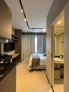 a bedroom with a bed and a bathroom with a sink at Studio Perdizes Allianz in Sao Paulo