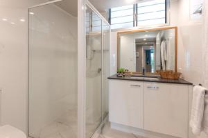 a bathroom with a glass shower and a sink at Frangipani Apartments on Hamilton Island by HIHA in Hamilton Island +138 photos
