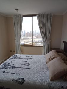 a bedroom with a bed and a large window at Amoblados MyK Portal Heroes, Mall Plaza in Iquique +6 photos