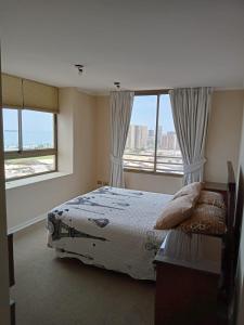 a bedroom with a bed and a large window at Amoblados MyK Portal Heroes in Iquique