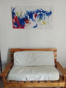 a wooden bench with a painting on the wall at Casa Norte in Diamante