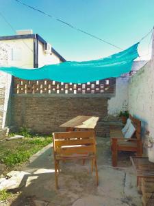 a picnic table and benches in a patio with a blue umbrella at Casa Norte in Diamante