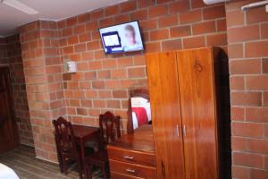 een kamer met een bakstenen muur, een bureau en een tafel bij Hotel International in Pedernales
