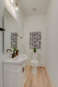 a white bathroom with a sink and a toilet at Luxury Downtown Nash/Roofdeck/11 Beds in Nashville +17 photos