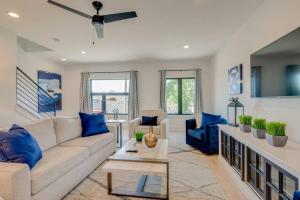 a living room with a white couch and blue pillows at Luxury Downtown Nash/Roofdeck/11 Beds in Nashville