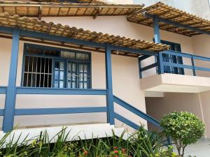 a house with blue trim and a balcony at Casa de Praia - meu lugar em Iriri in Anchieta