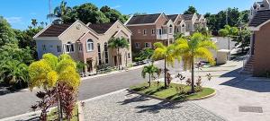 a row of houses with palm trees in a courtyard at Komfort Getaway Villa in Ocho Rios