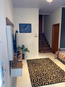 a living room with a bed and a rug at Sunshine Chalé Brasília-DF in Brasília