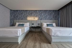 2 camas en una habitación de hotel con 2 camas sidx sidx sidx en Hotel Estancia Business Class, en Guadalajara