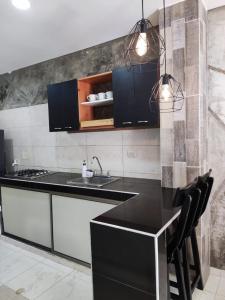 a kitchen with a black counter and a sink at zara's apartamento en coveñas in Coveñas
