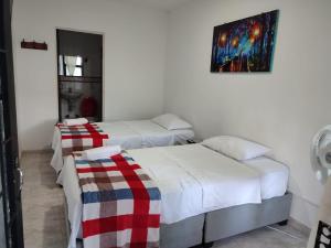ein Schlafzimmer mit 2 Betten und einem Wandgemälde in der Unterkunft HOTEL POSADA CAMPESTRE SAN JUAN in Monterrey