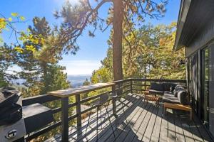 een terras met een bank en stoelen in een huis bij Updated Mountain Cabin Retreat with 180 views off Deck and Balcony in Running Springs
