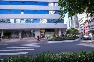 una persona cruzando una calle frente a un edificio en Apartamento AV. Brasil Frente Sh. Atlântico, en Balneário Camboriú